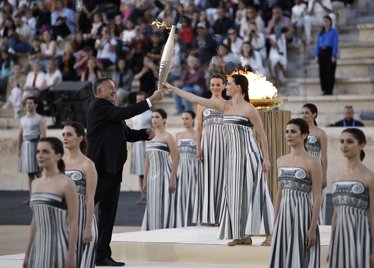 Greek actress Mary Mina, playing the role of High Priestess, gives the torch to President of the Hellenic Olympic Committee and member of the International Olympic Committee Spyros Capralos during the Handover Ceremony. 