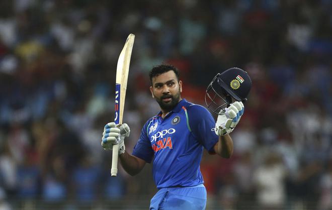 India captain Rohit Sharma lifts his club and wears a helmet to celebrate his century during the Asia Cup match against Pakistan in Dubai on September 23, 2018. 
