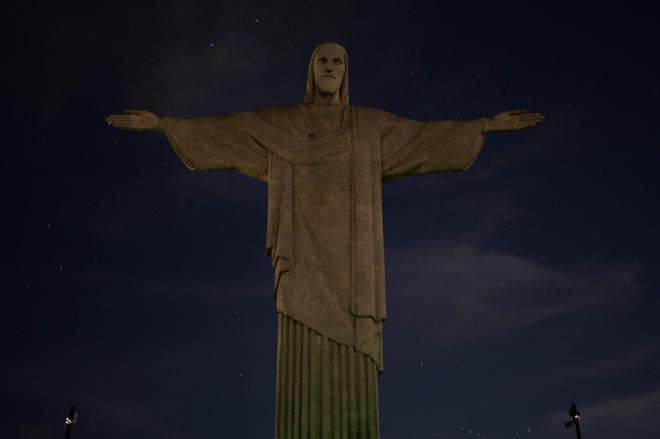 TOPSHOT - The Christ the Redeemer statue is seen without illumination to condemn racist acts against Brazilian footballer Vinicius Junior in Rio de Janeiro, Brazil, on May 22, 2023. The world-famous landmark had its illumination turned off for one hour in solidarity with Real Madrid's player Vinicius Junior, who was the target of persistent racist abuse during his team’s 1-0 defeat to Valencia at the Mestalla Stadium in Spain’s La Liga on May 21, 2023. The act was described 'as a symbol of the collective struggle against racism and in solidarity with the player and all those who suffer prejudice around the world.' (Photo by CARLOS FABAL / AFP)