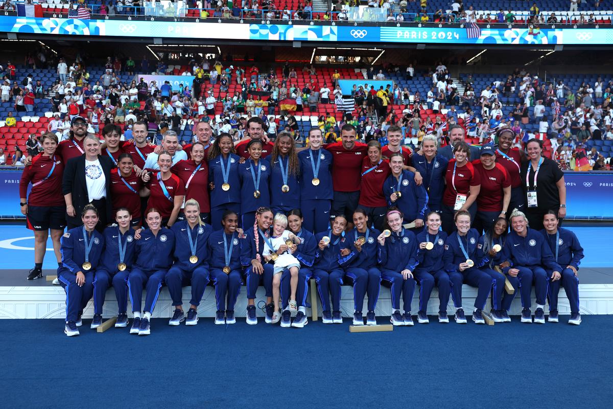 Gold Medalists of Team United States pose for a photo on the podium with Emma Hayes’ son, Harry, during the Women’s Football Medal Ceremony during the Olympic Games Paris 2024 at Parc des Princes on August 10, 2024 in Paris, France. 