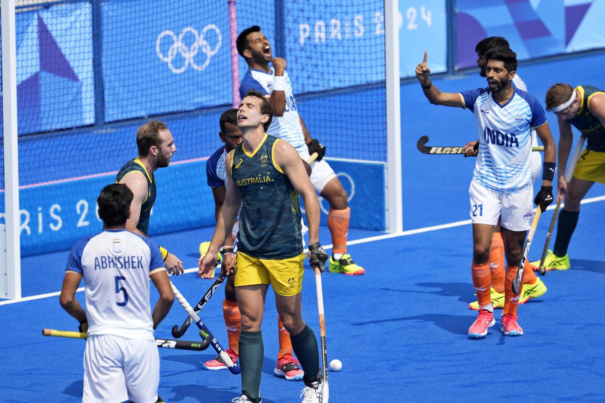 Australia’s Thomas Craig, center, reacts as Indian players jubilate on the end of the men’s field hockey match between Australia and India. 