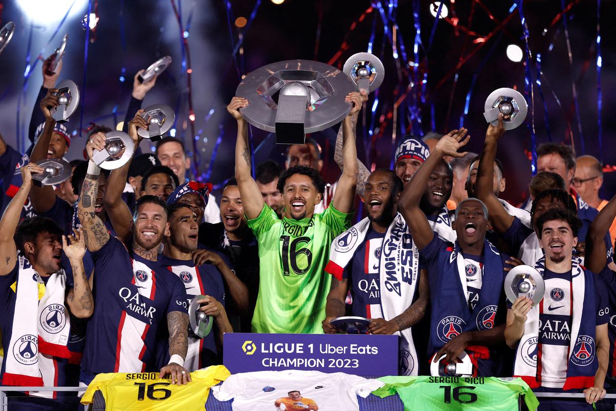 Paris St Germain’s Marquinhos and team mates celebrate winning the Ligue 1 with the trophy.