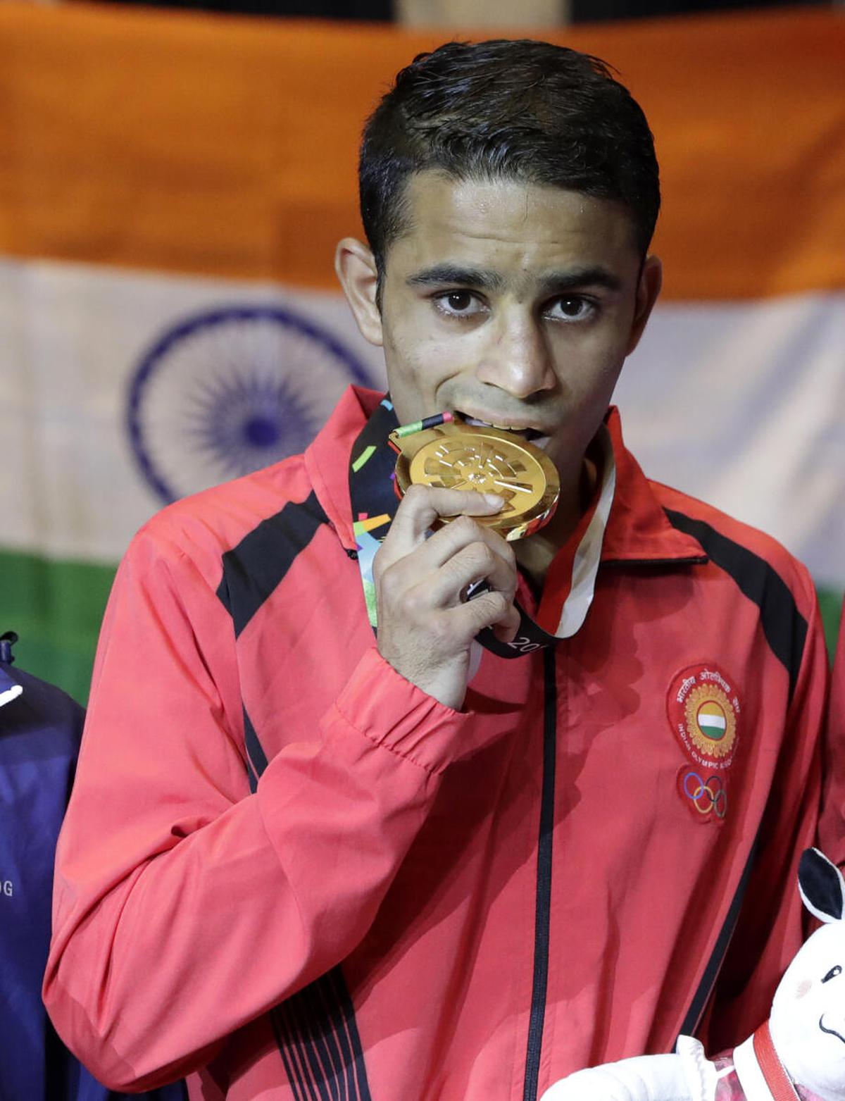 India’s Amit Panghal, bites his medal on the podium after defeating Uzbekistan’s Dusmatov Hasanboy in their men’s light flyweight boxing final at the 18th Asian Games in Jakarta, Indonesia, Saturday, Sept. 1, 2018.