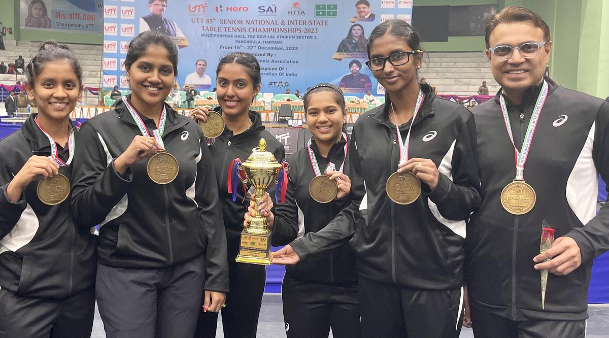 Reserve Bank of India women’s team, and coaches, proudly pose with the winners’ trophies and gold medals after retaining the team titles.