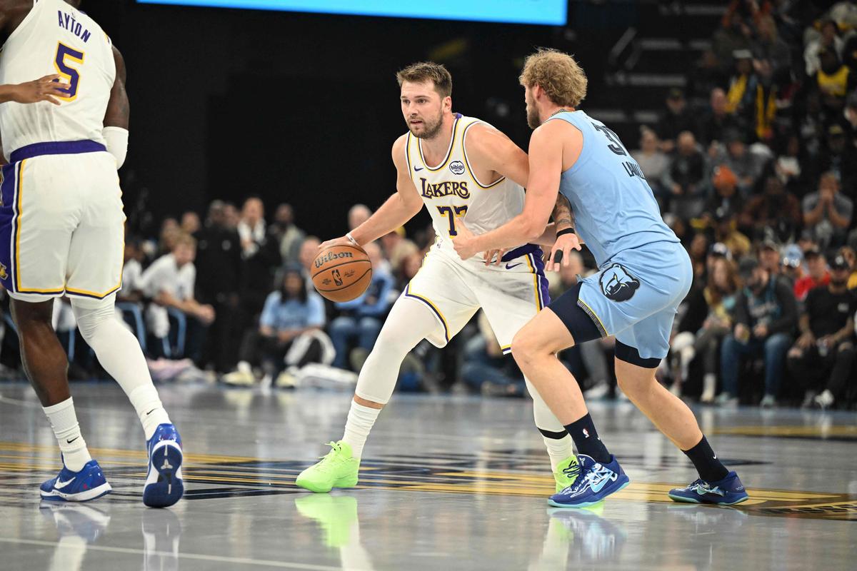 Luka Doncic #77 of the Los Angeles Lakers is guarded by Jock Landale #31 of the Memphis Grizzlies during an NBA Cup game. 