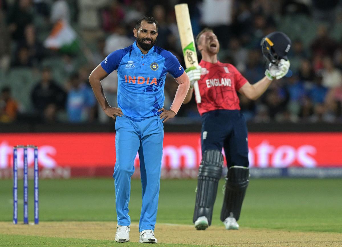 England’s Captain Jos Buttler (R) celebrates after victory as India’s Mohammed Shami. 