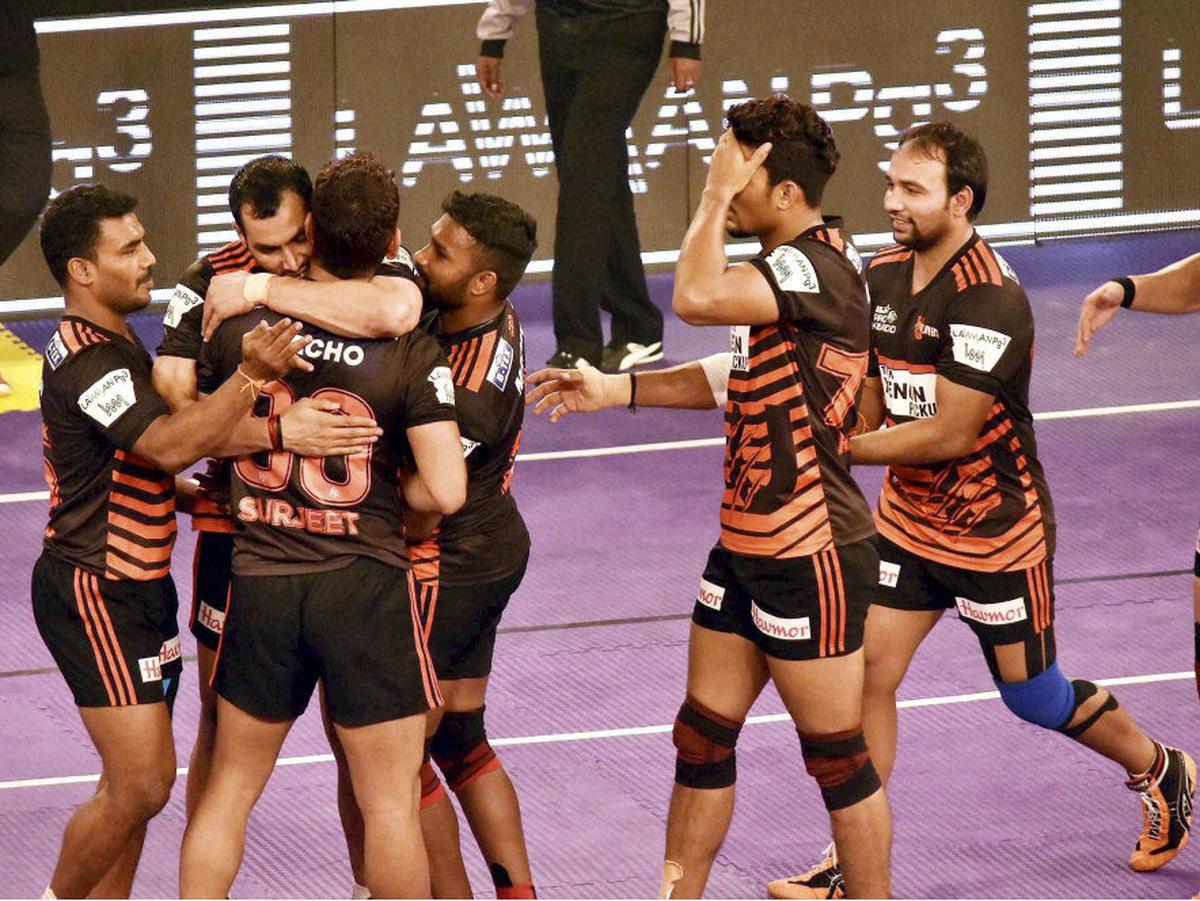 Bengaluru Bulls' players pin down a U Mumba player, Shiv Om, in