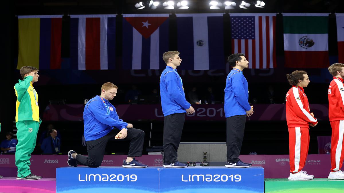 Fencer Race Imboden takes the knee during American anthem